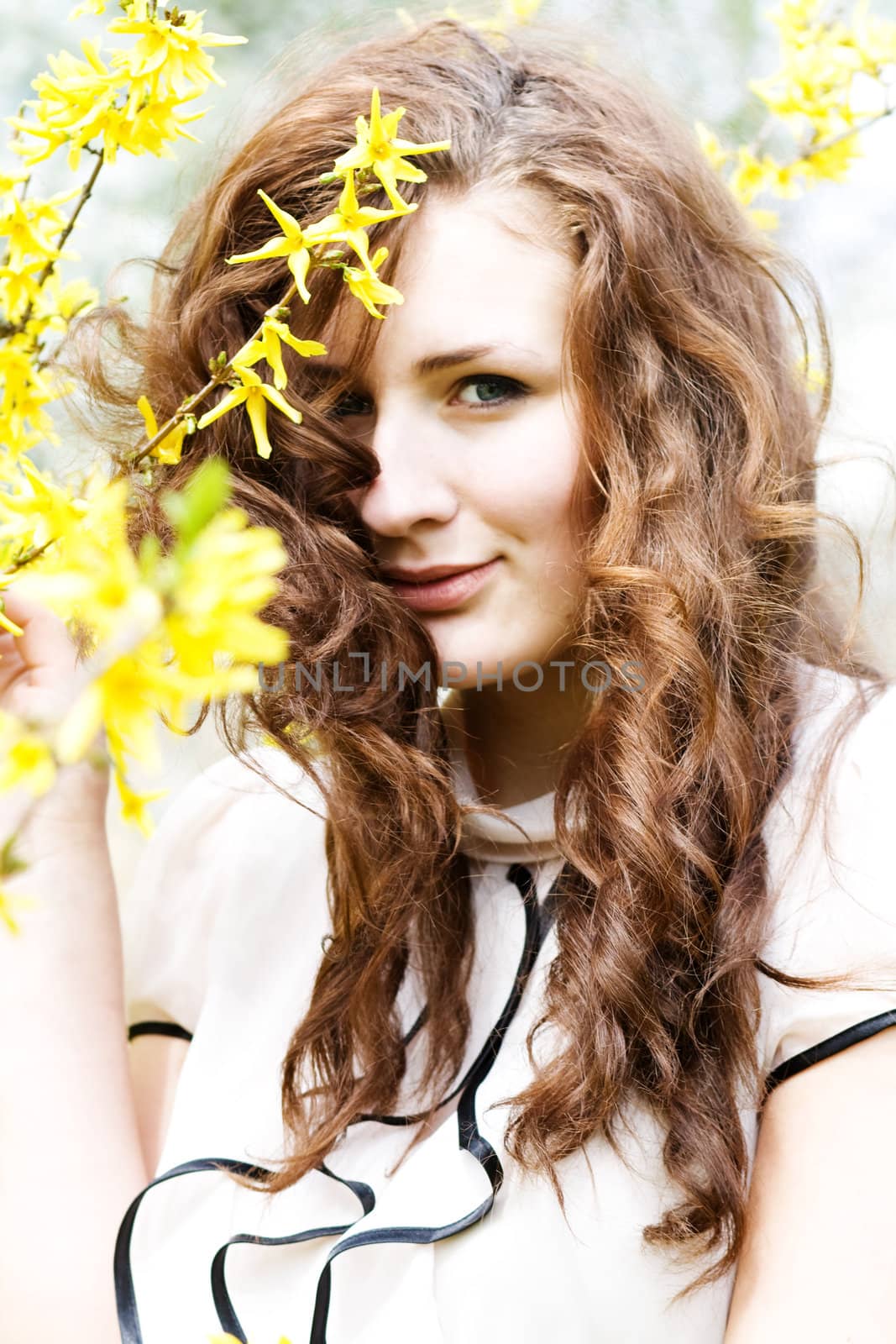 beautiful young woman in a flowering spring tree