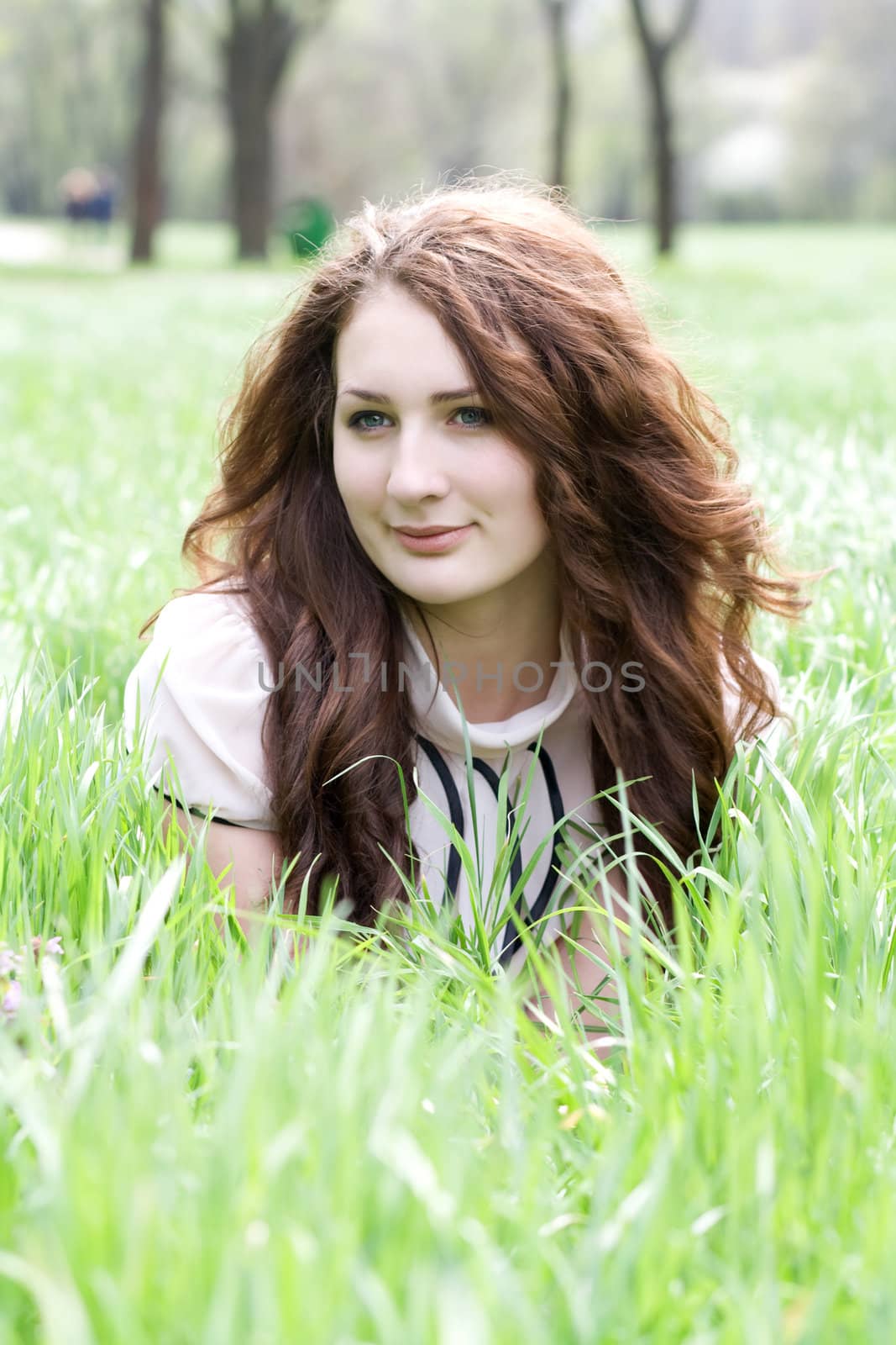 An image of a beautiful girl lying down on the grass