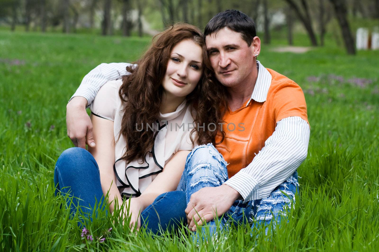 Man and woman embracing sitting on the grass