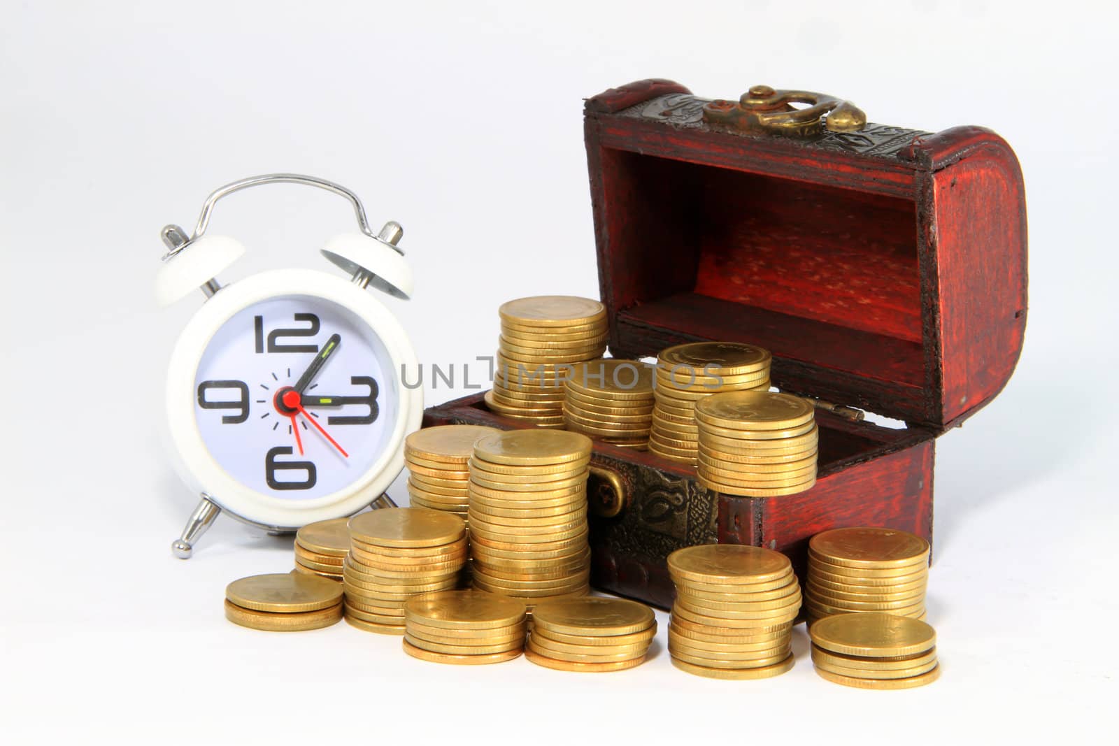 Gold alarm clock lay on money in a wooden chest