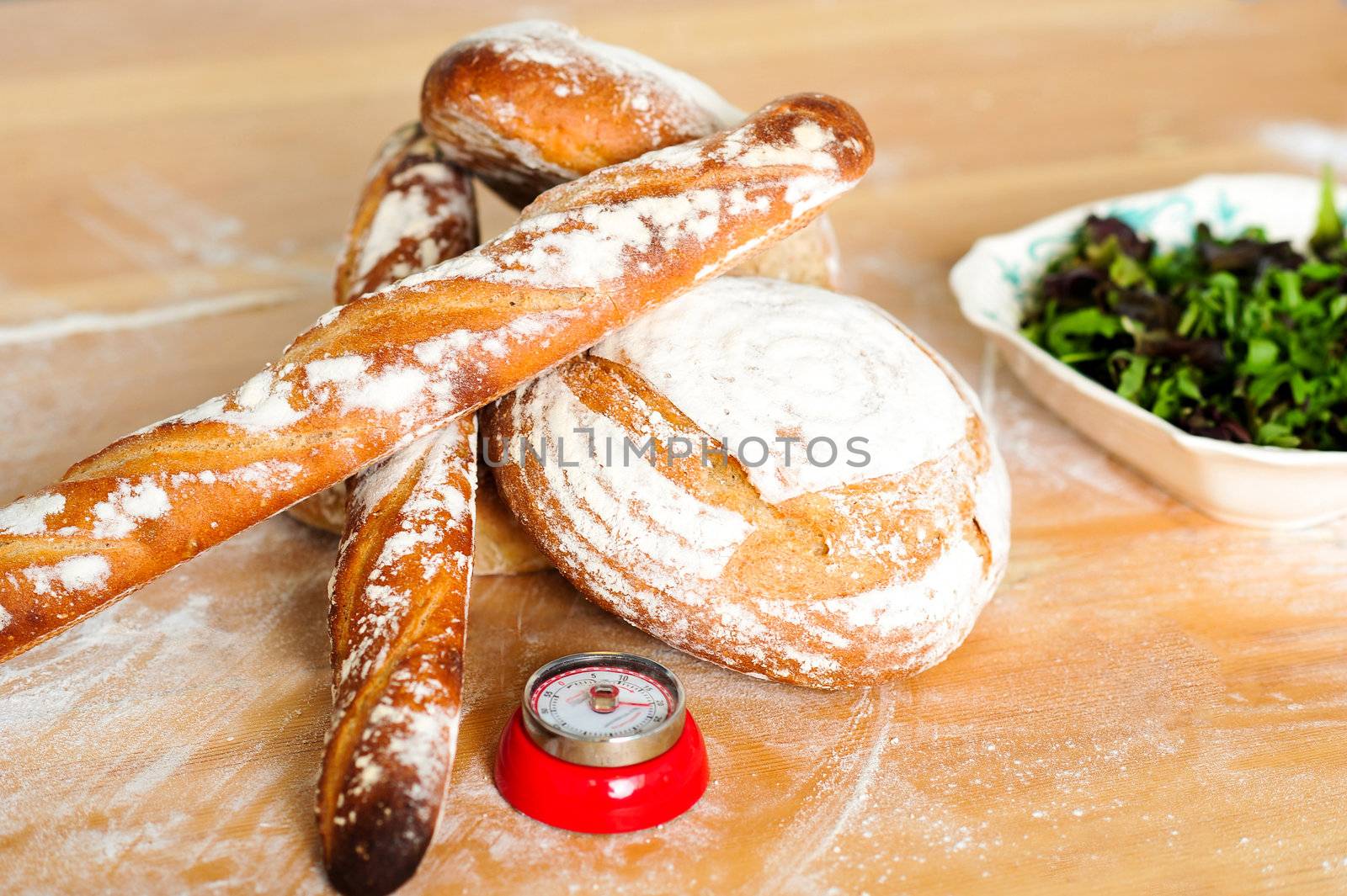 Closeup of baguettes and breads with green salad