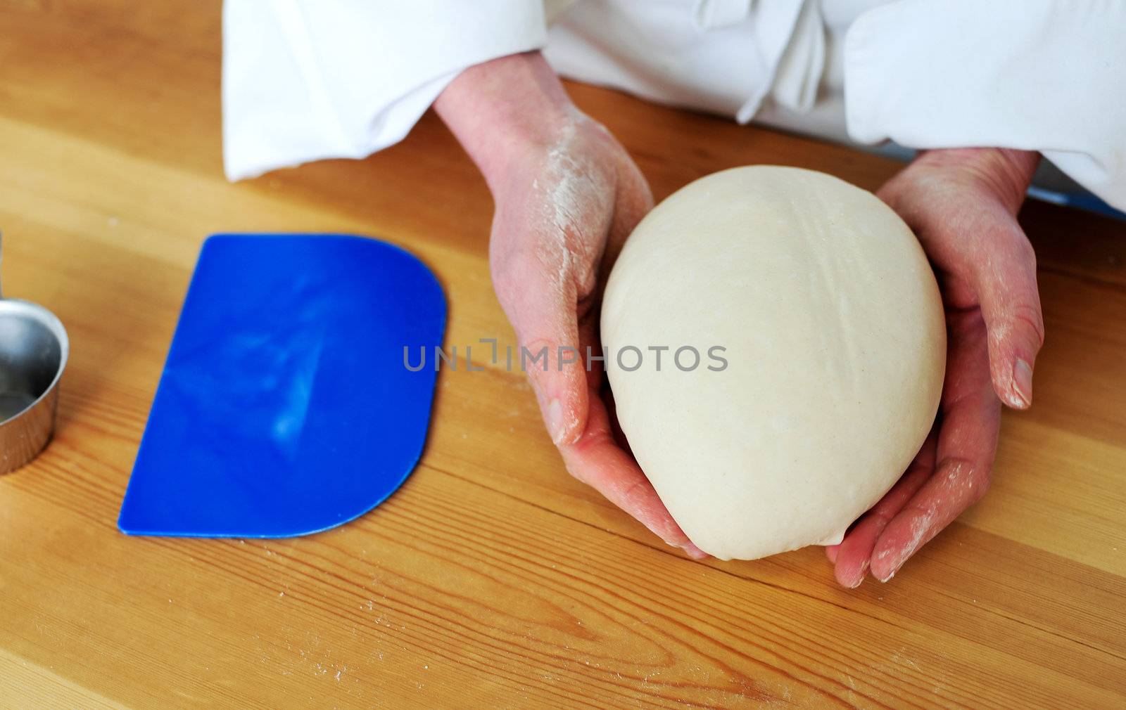 Chefs hand holding a clean finished dough. Closeup shot