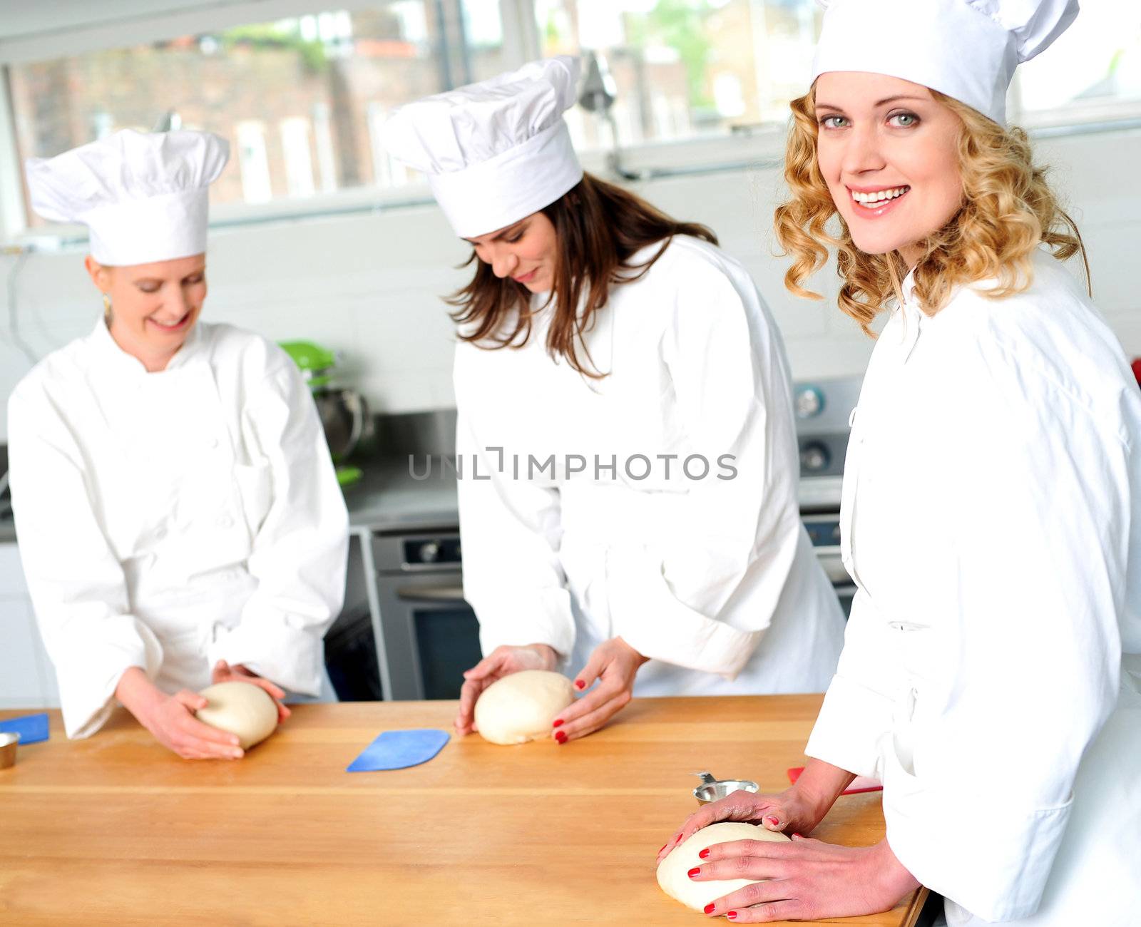 Female chefs at work in a restaurant kitchen by stockyimages