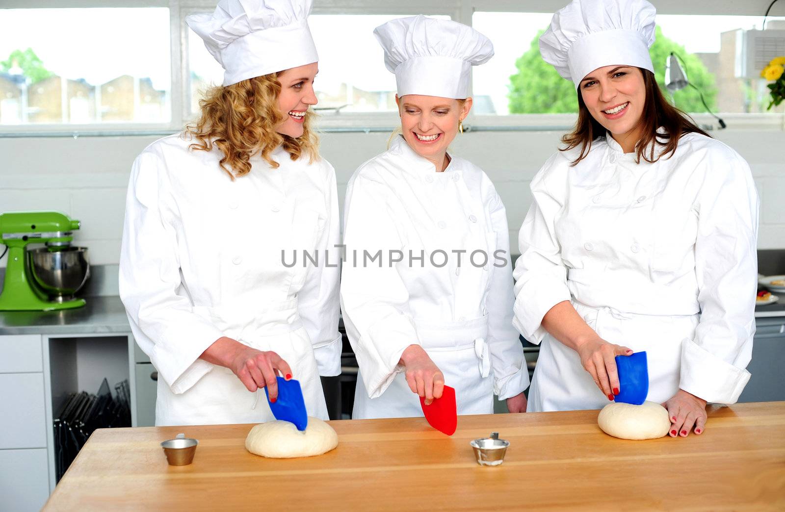 Professional chefs kneading bread dough on a cutting board