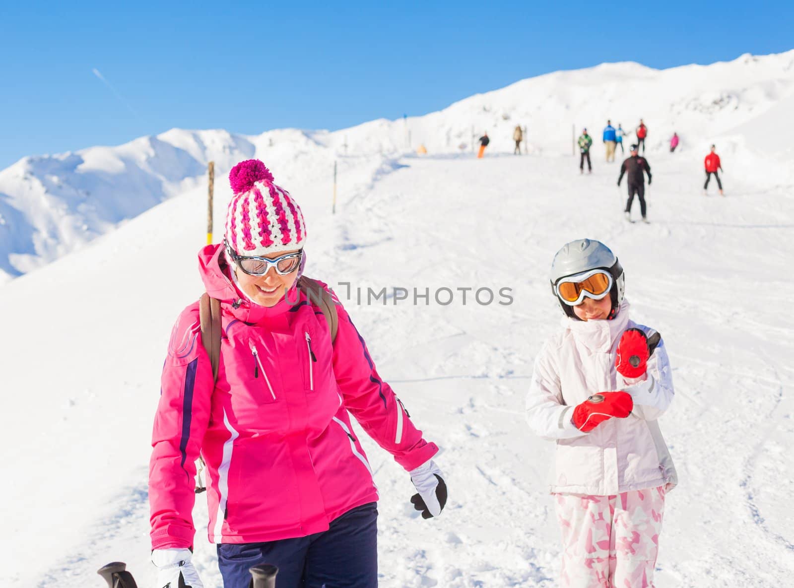 Happy smiling girl in ski goggles and a helmet with his mother, Zellertal, Austria