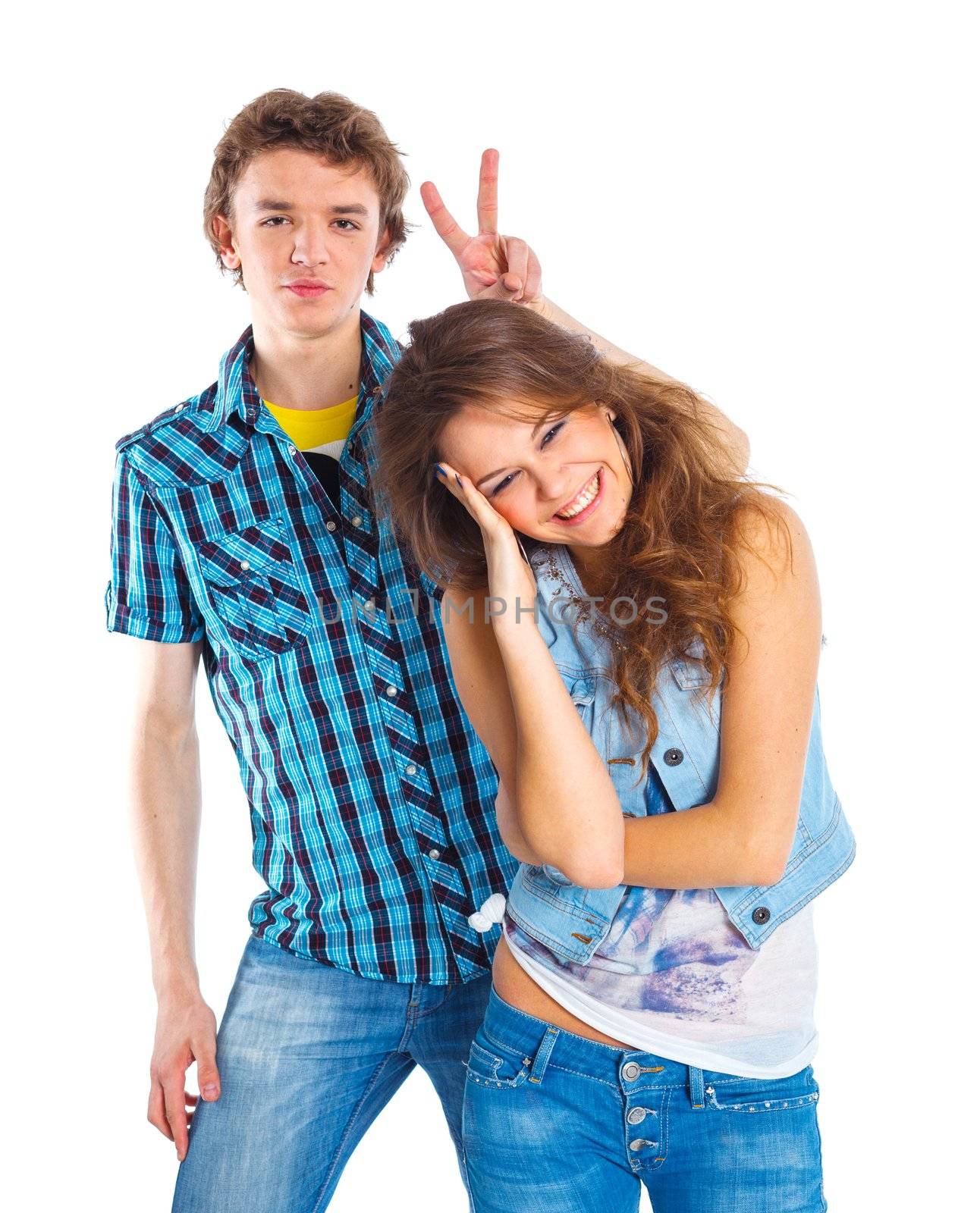 Smiling teenager boy indulge his pretty girlfriend. Isolated on white background.