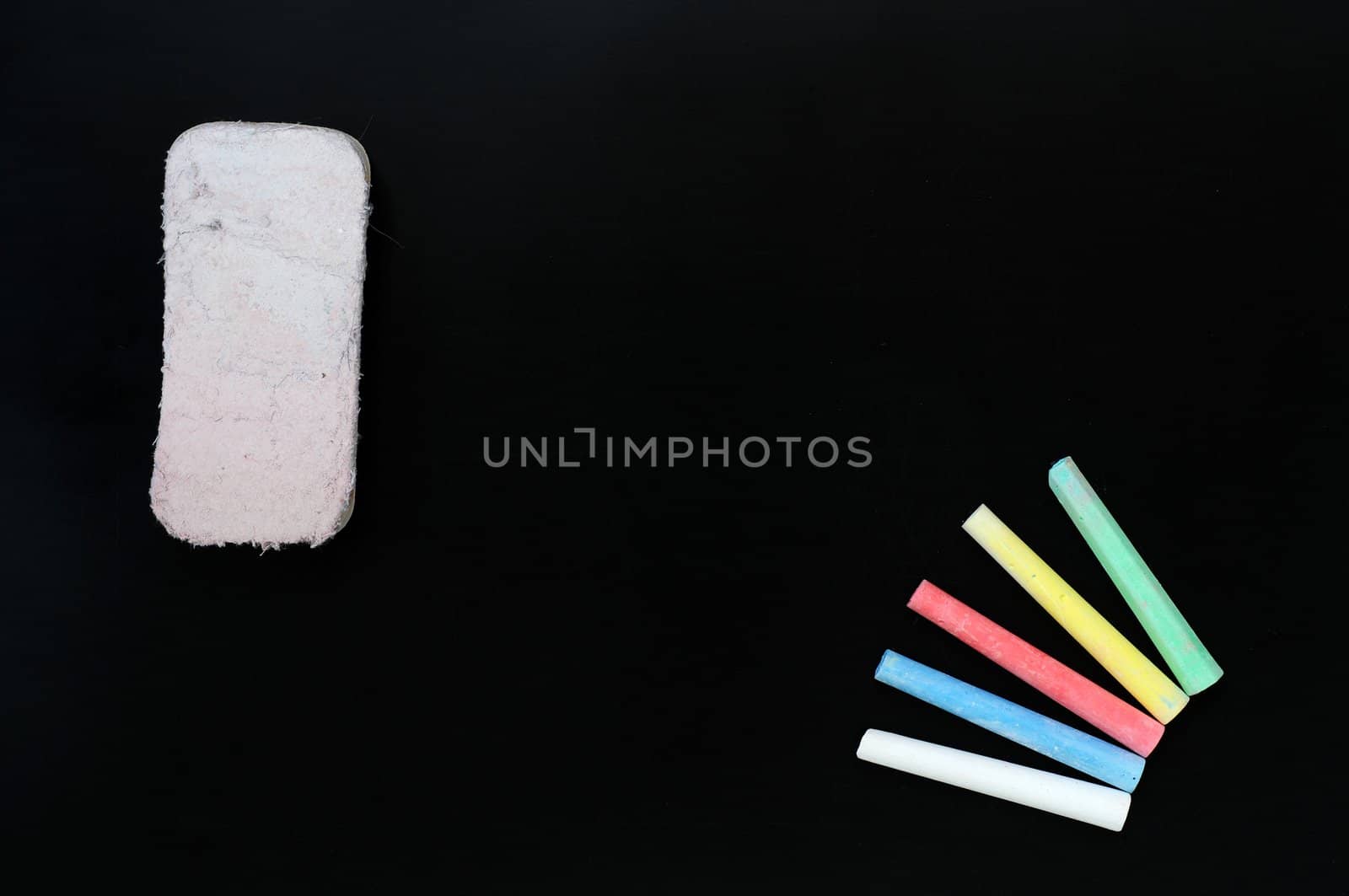 Blank blackboard background with colorful chalk and eraser for text writing and design