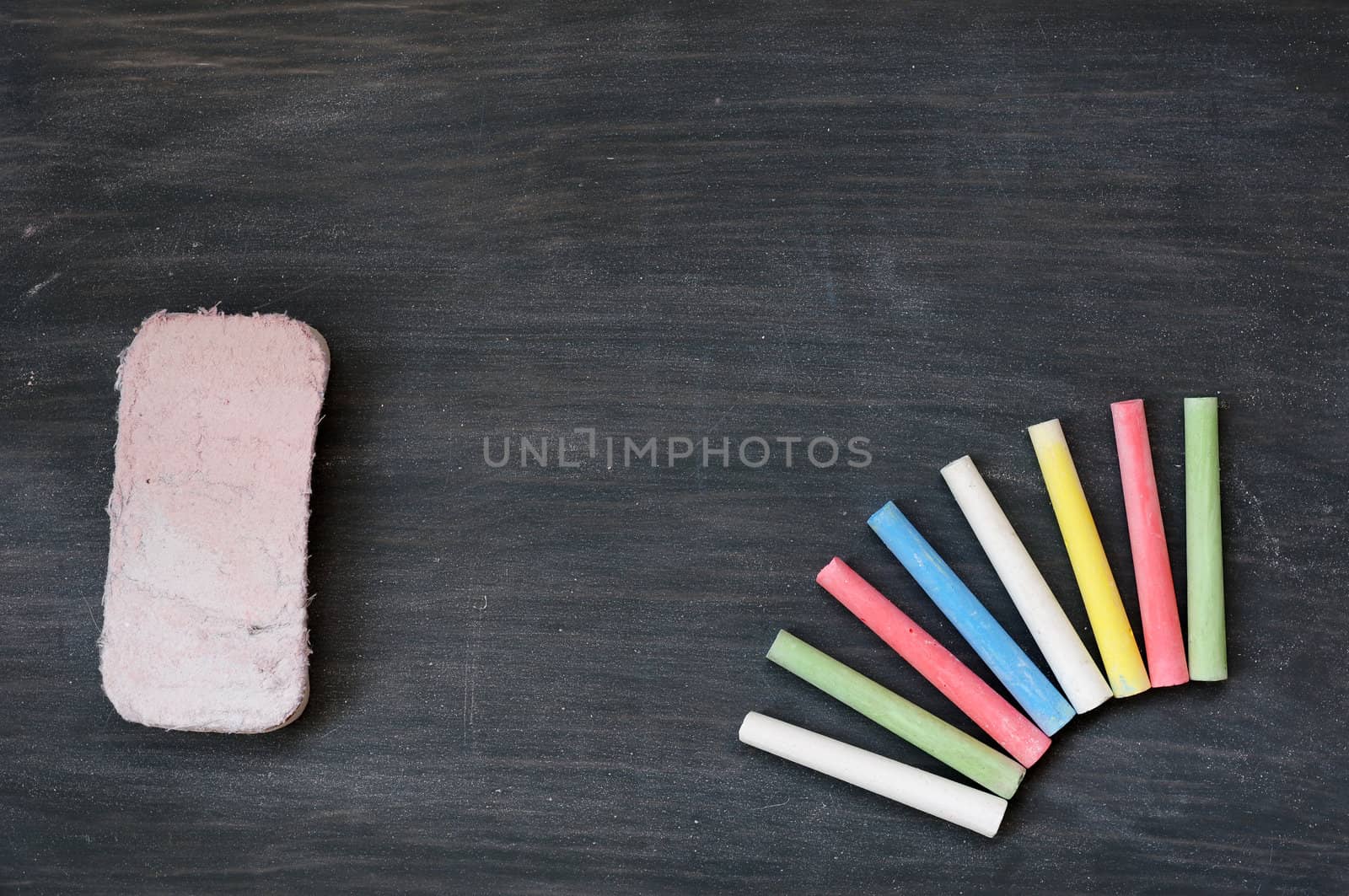 Blank smudged blackboard background with colorful chalk and eraser for text writing and design