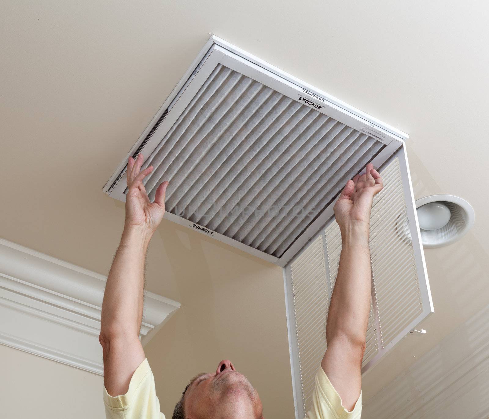 Senior man opening air conditioning filter in ceiling by steheap