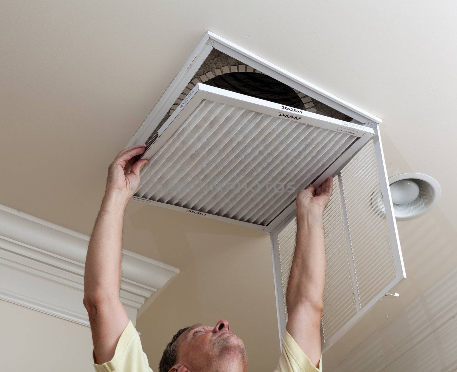 Senior man opening air conditioning filter in ceiling by steheap