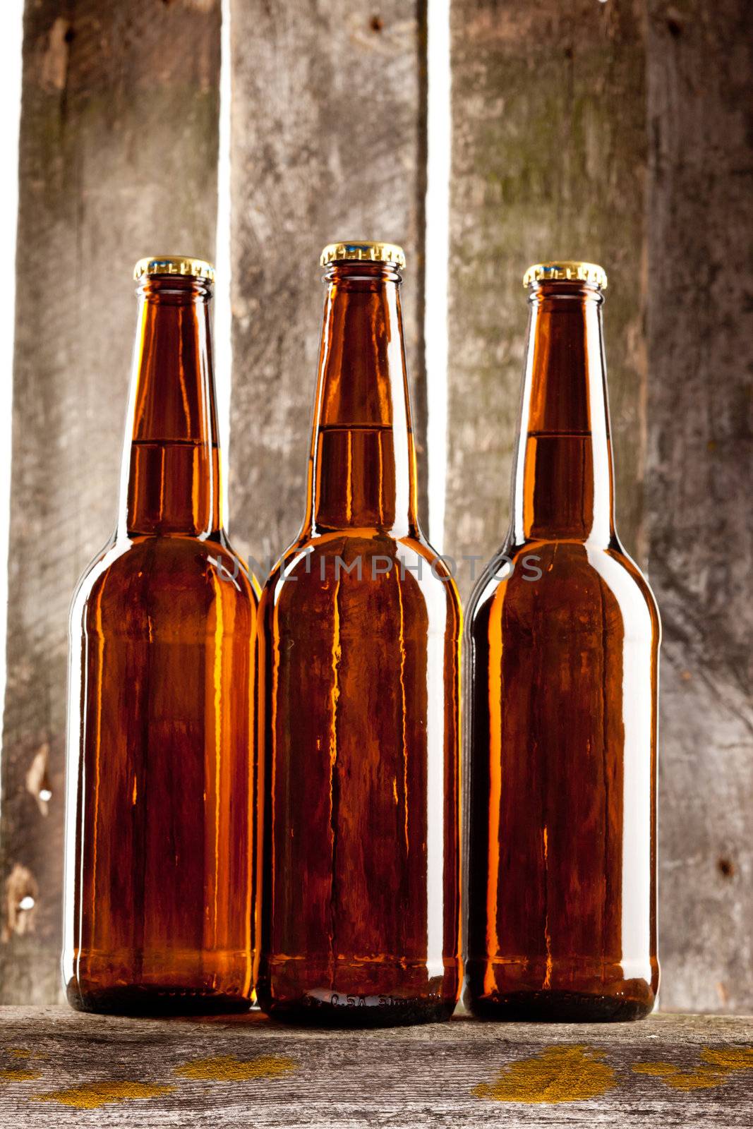 three beer bottle on old wooden plank backbround