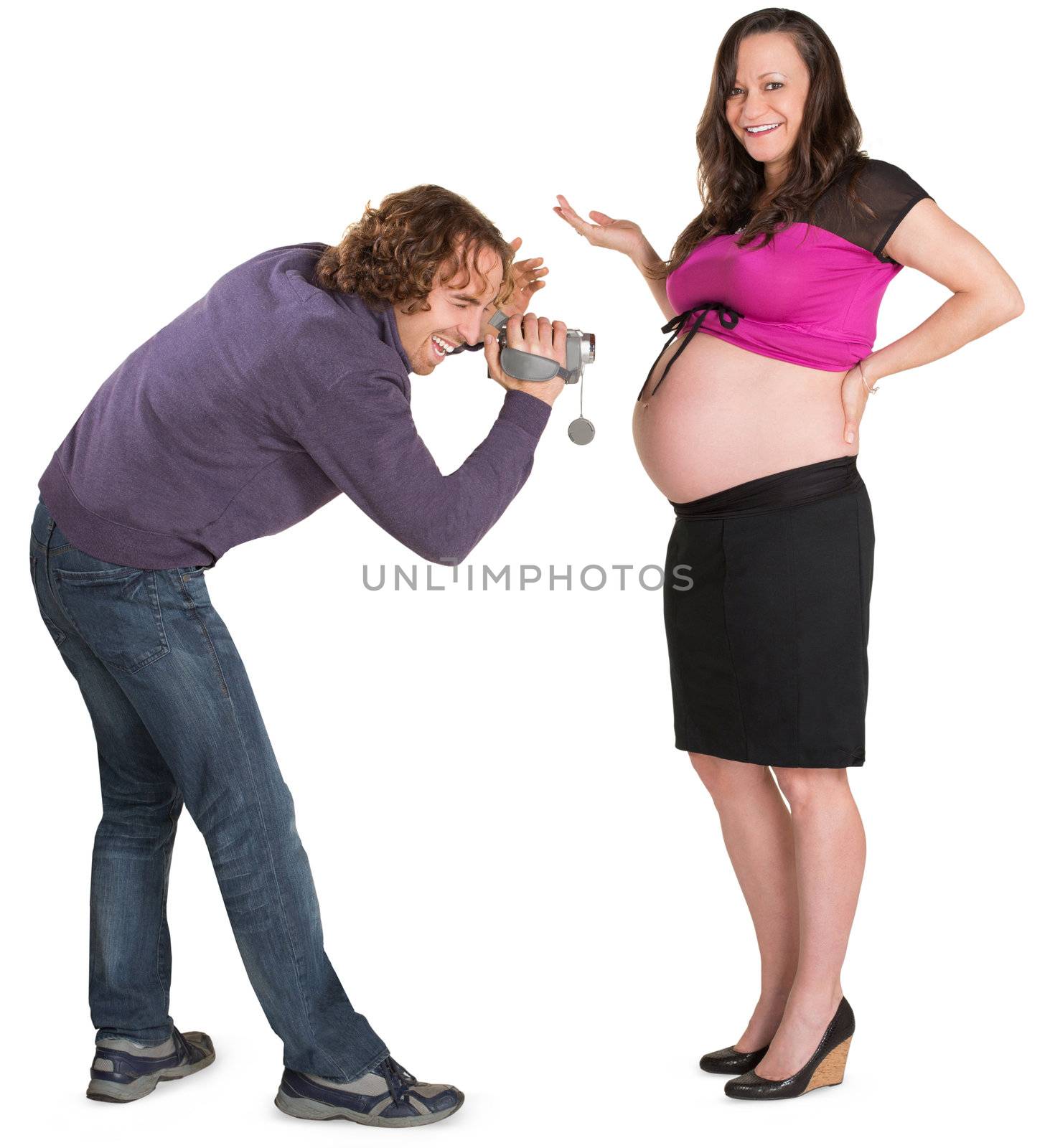 Father holding camcorder in front of pregnant wife 