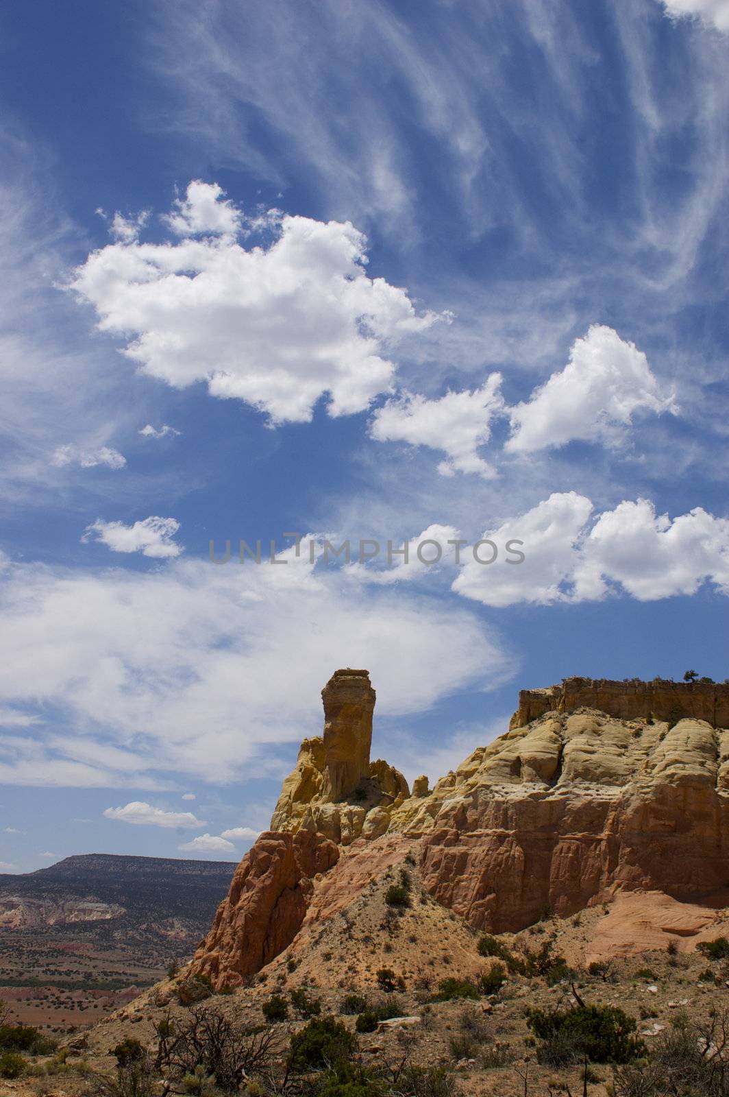 Featuring a rock formation at the red rock canyon/ mountain at Georgia O' Keefe's Ghost Ranch, New Mexico against a blue cloudy sky