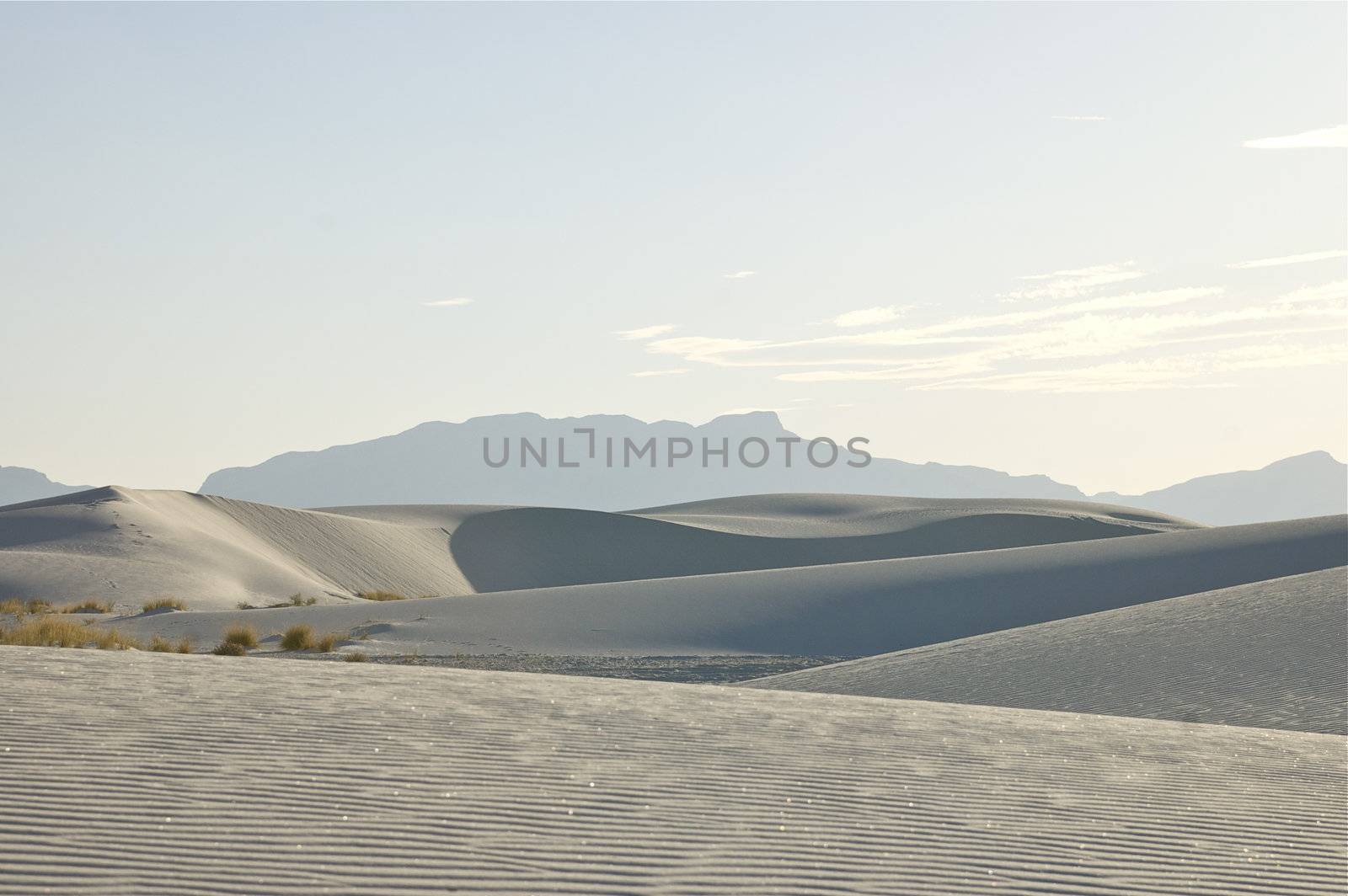 White Sands National Monument at sunset, featuring hills and dunes against the horizon, New Mexico