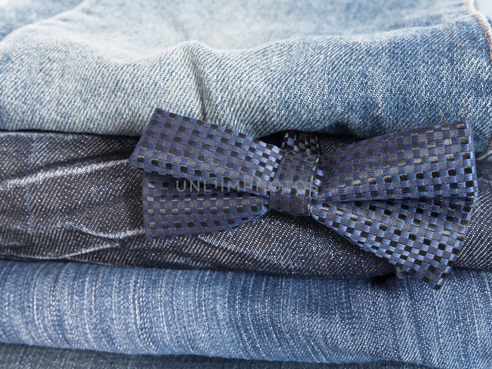 heap of jeans and decorative tie as a fashion background by Serp