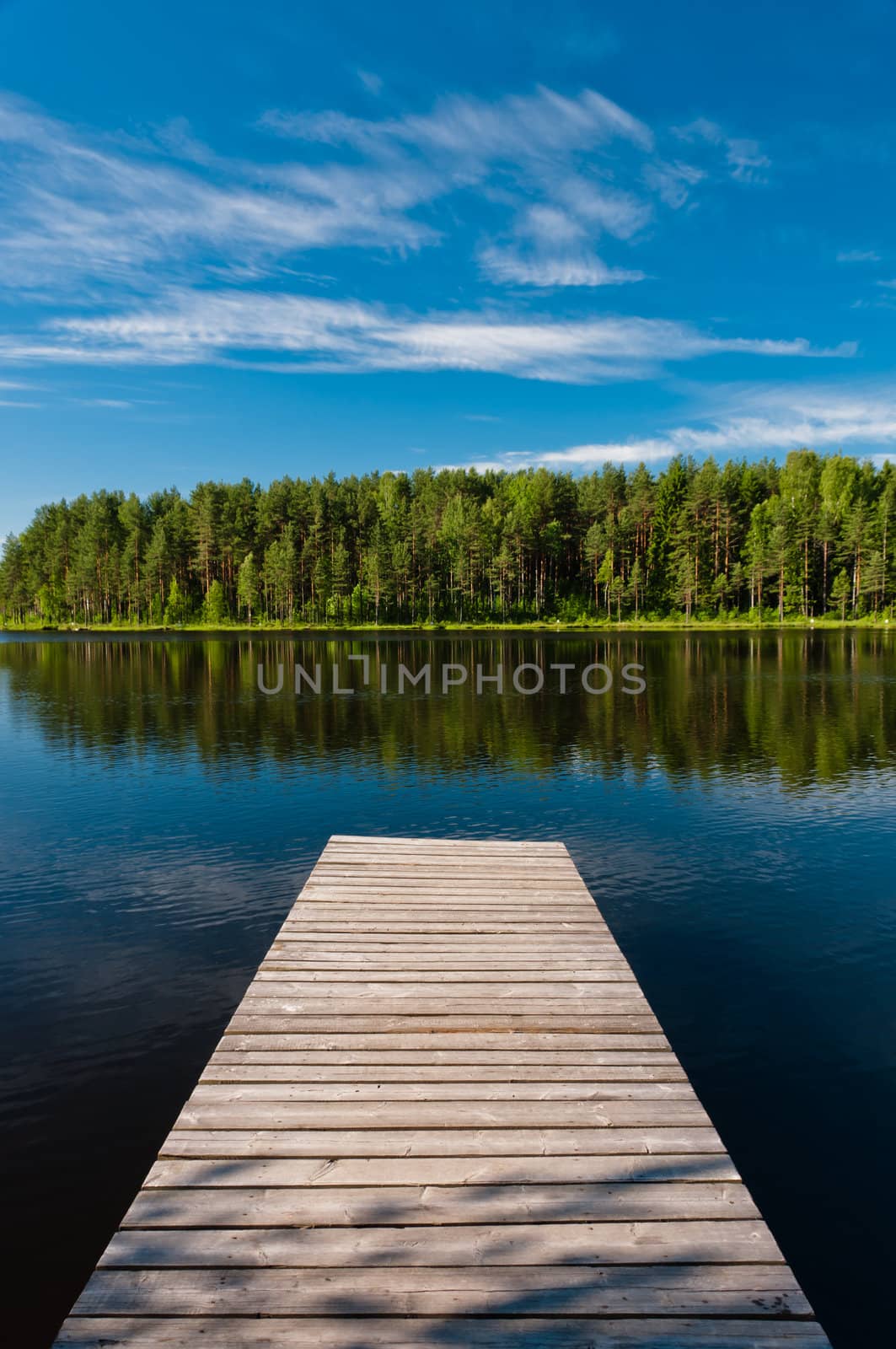 Wooden pier on lake symmetrical scene by dmitryelagin