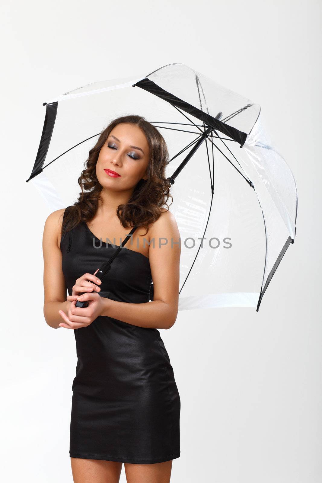 Portrait of young woman with umbrella in studio