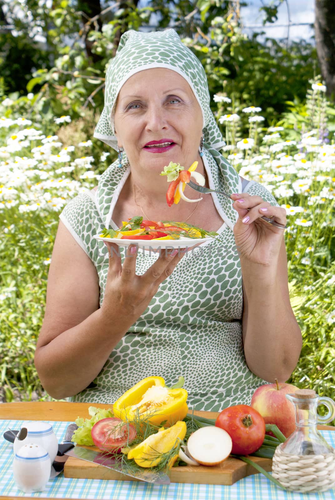 The adult woman eats appetizing fresh vegetables salad