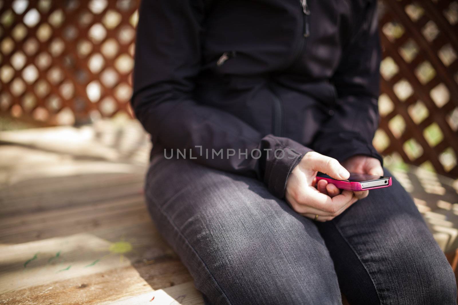 woman reading on her smart phone in a treehouse