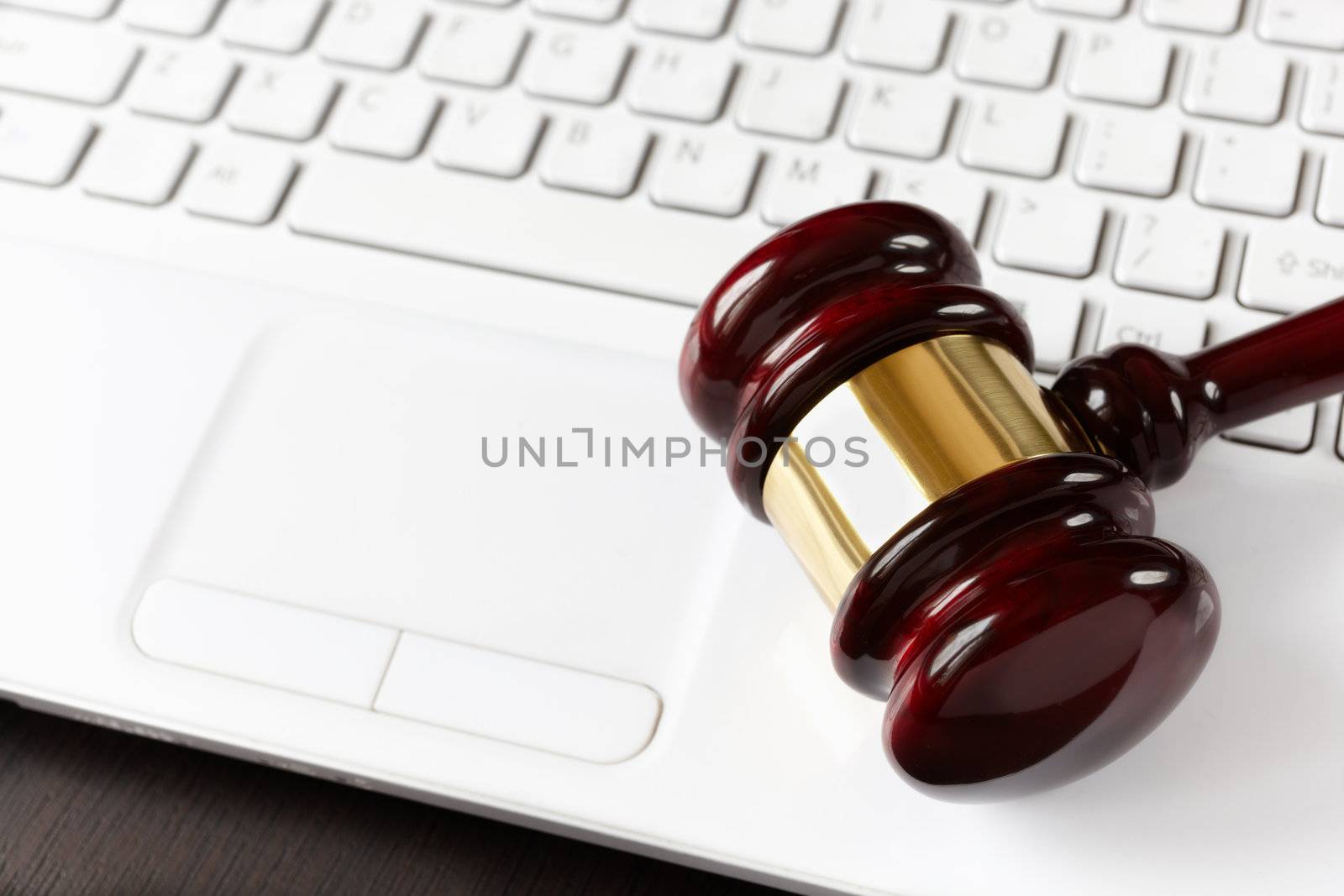 gavel on white laptop, selective focus on metal part