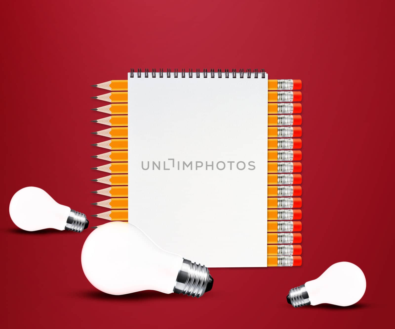 pencils and notepad and light bulb on red background.