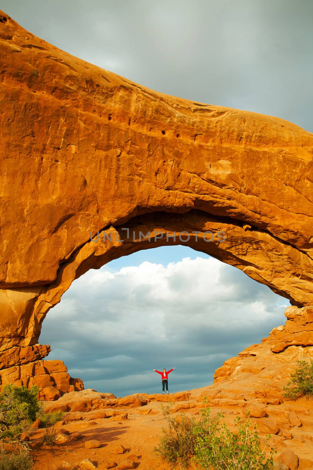 Woman staying with raised hands inside an Arch by AndreyKr