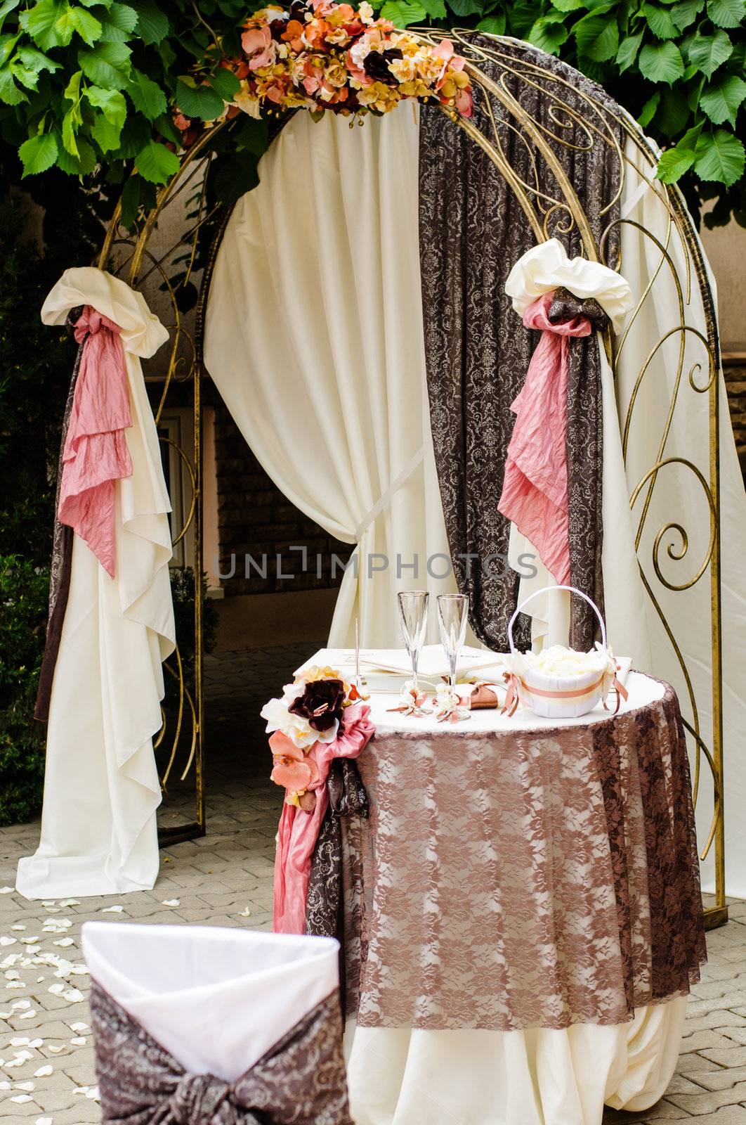 Outdoor wedding arch with table under grapevine