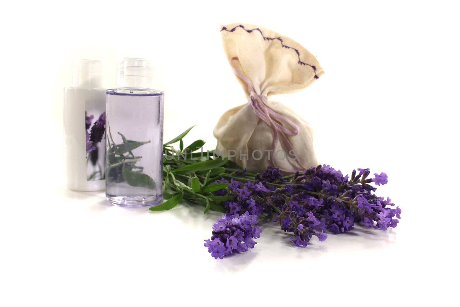 Lavender oil with Lavender bag and lilac flowers on a bright background