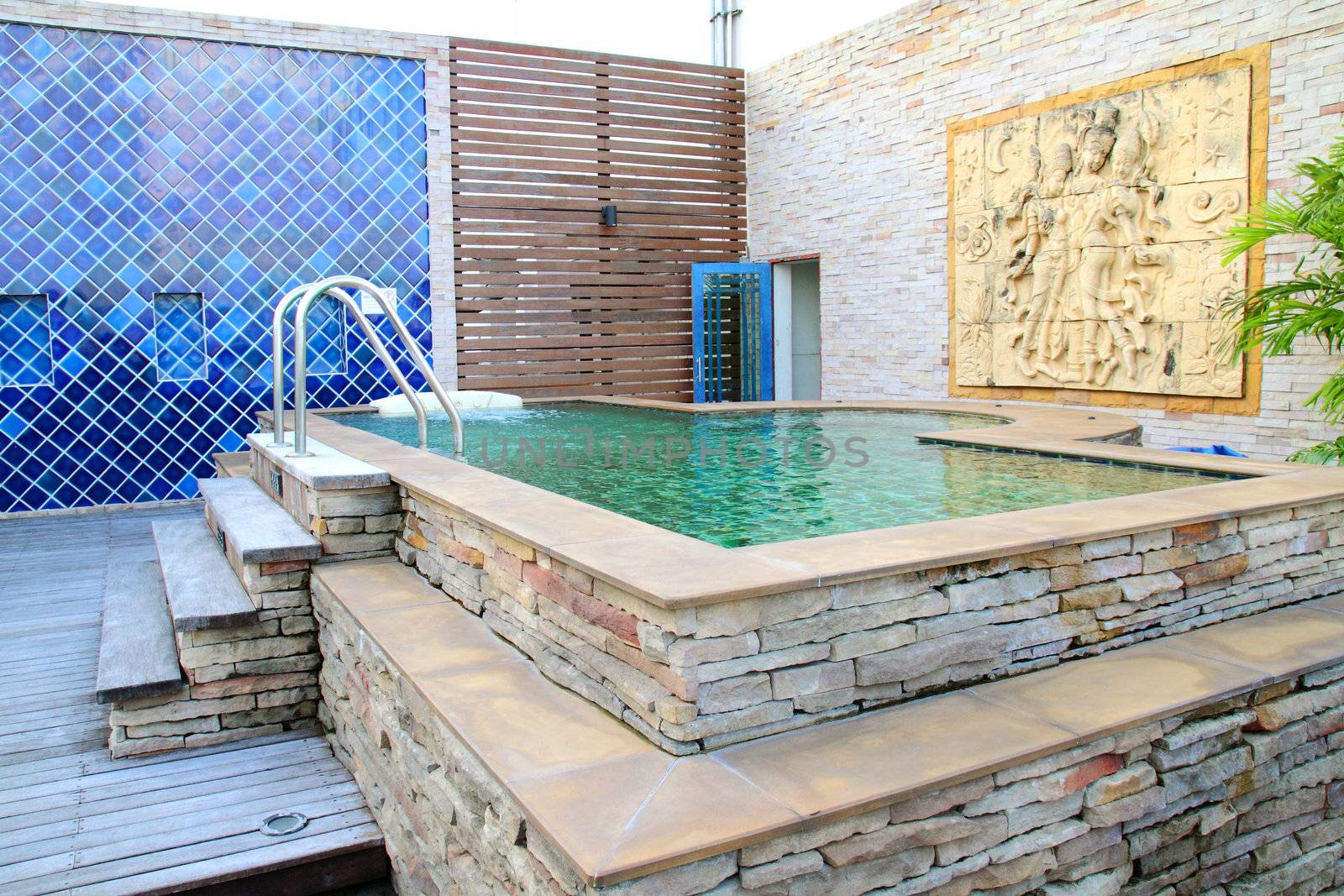 outdoor jacuzzi with thai stone carving wall  by nuchylee