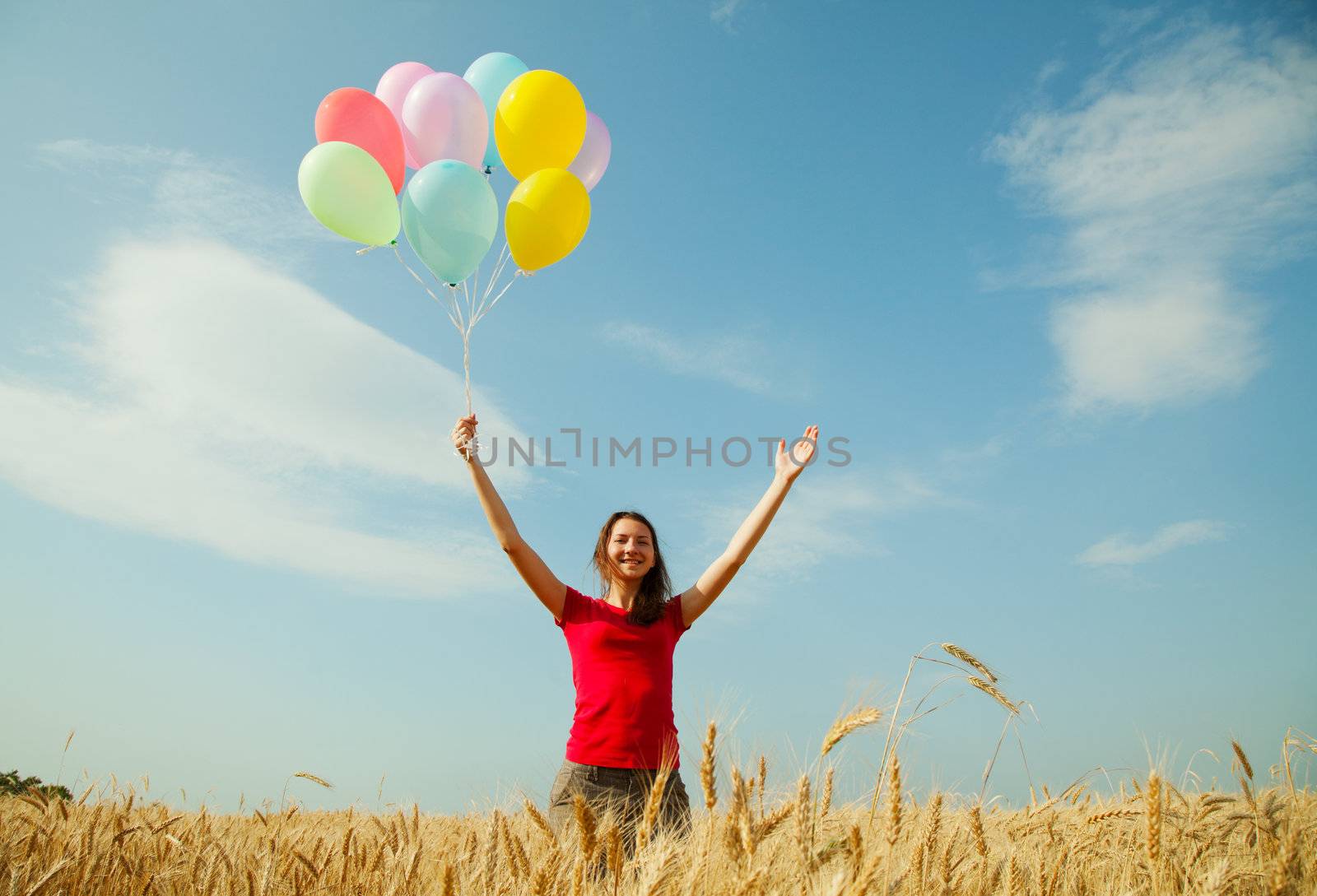 Teen girl at a wheat field with balloons