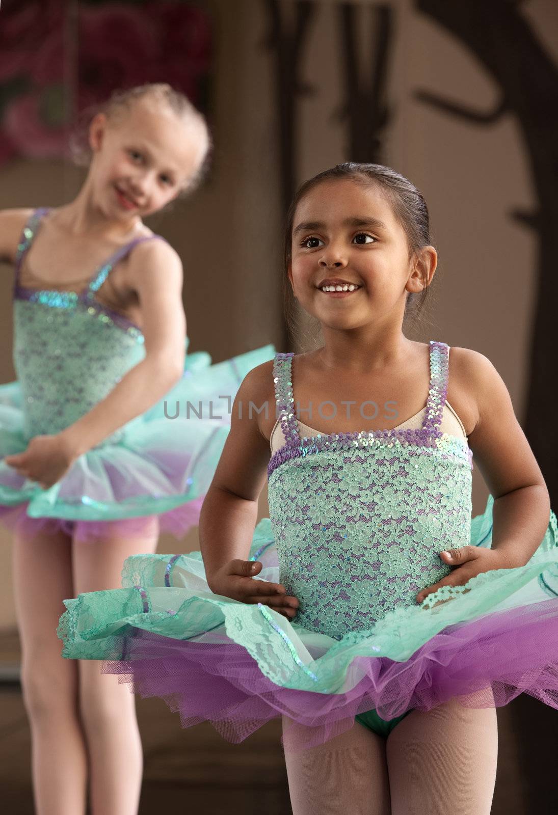 Two little ballet students practicing while laughing