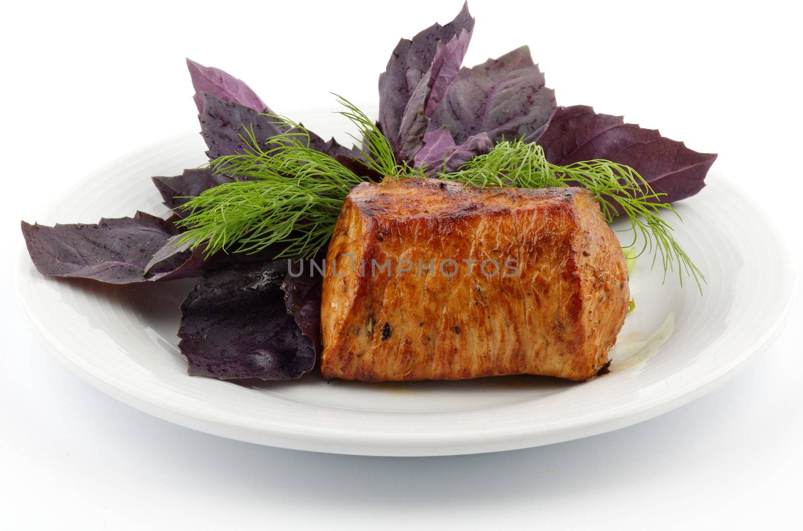 Spicy Roast Pork tenderloin with basil and dill closeup on white background