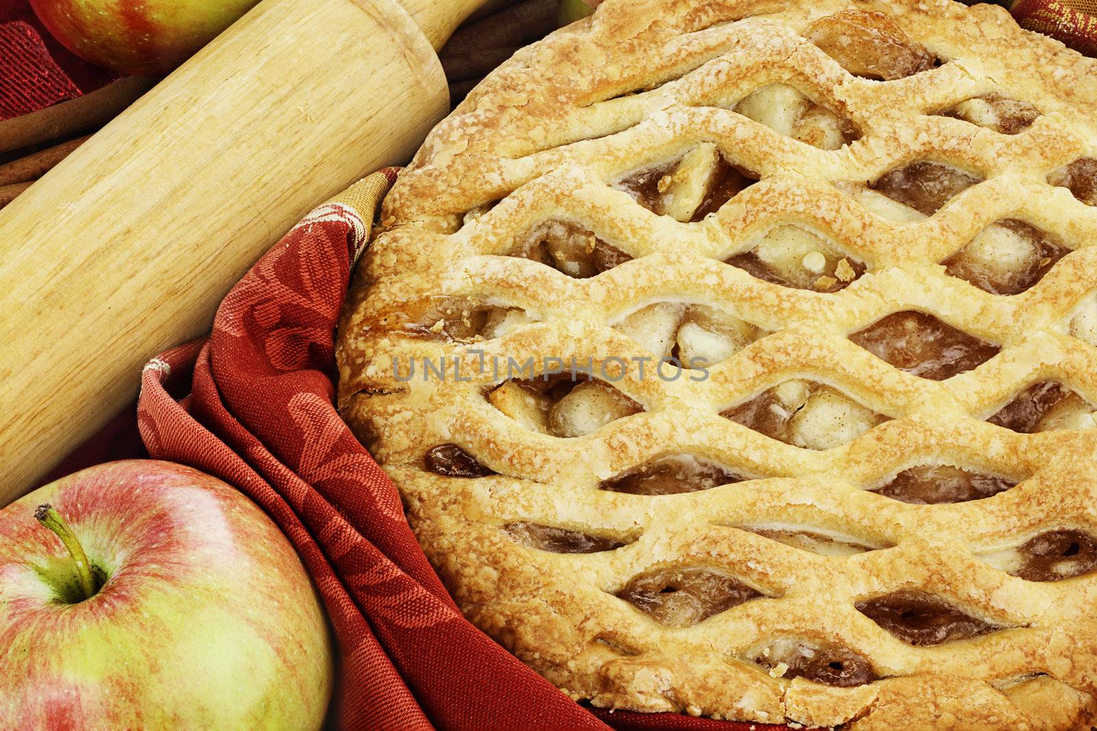 Delicious fresh baked apple pie with rolling pin and ingredients. Perfect for the holidays.