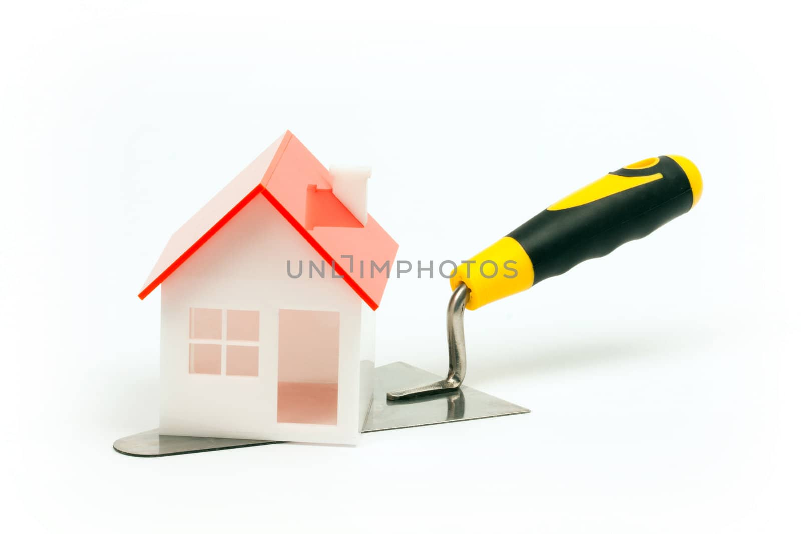 House model on construction trowel. New home concept