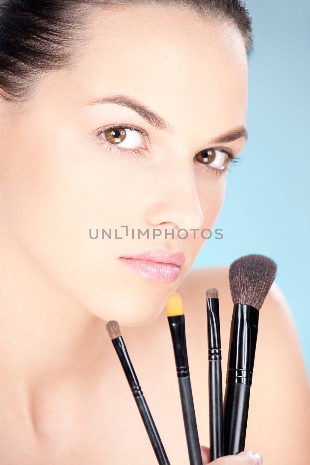 Pretty woman holding set of make up brushes