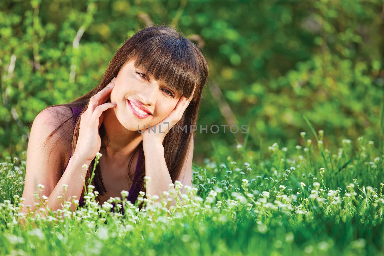 Cute brunette woman laying in the grass