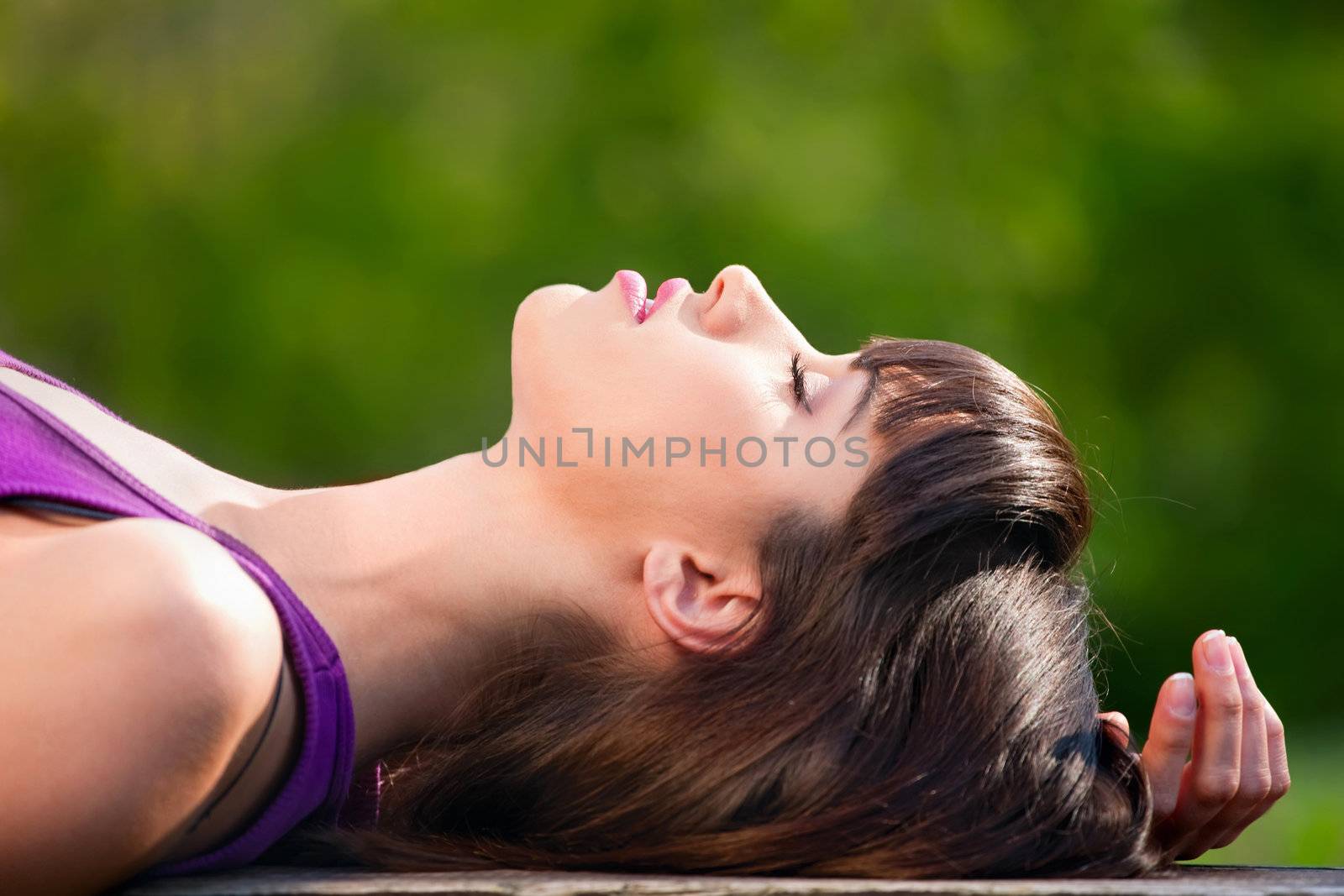 Young pretty woman relaxing outdoor on bank in spring time