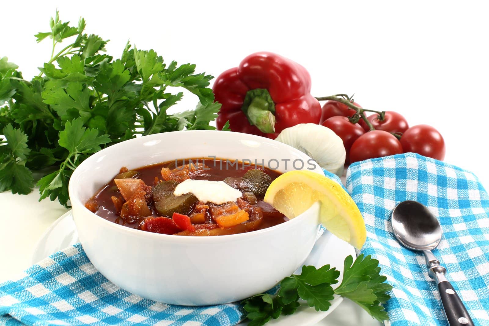 a bowl Solyanka with cream and lemon 