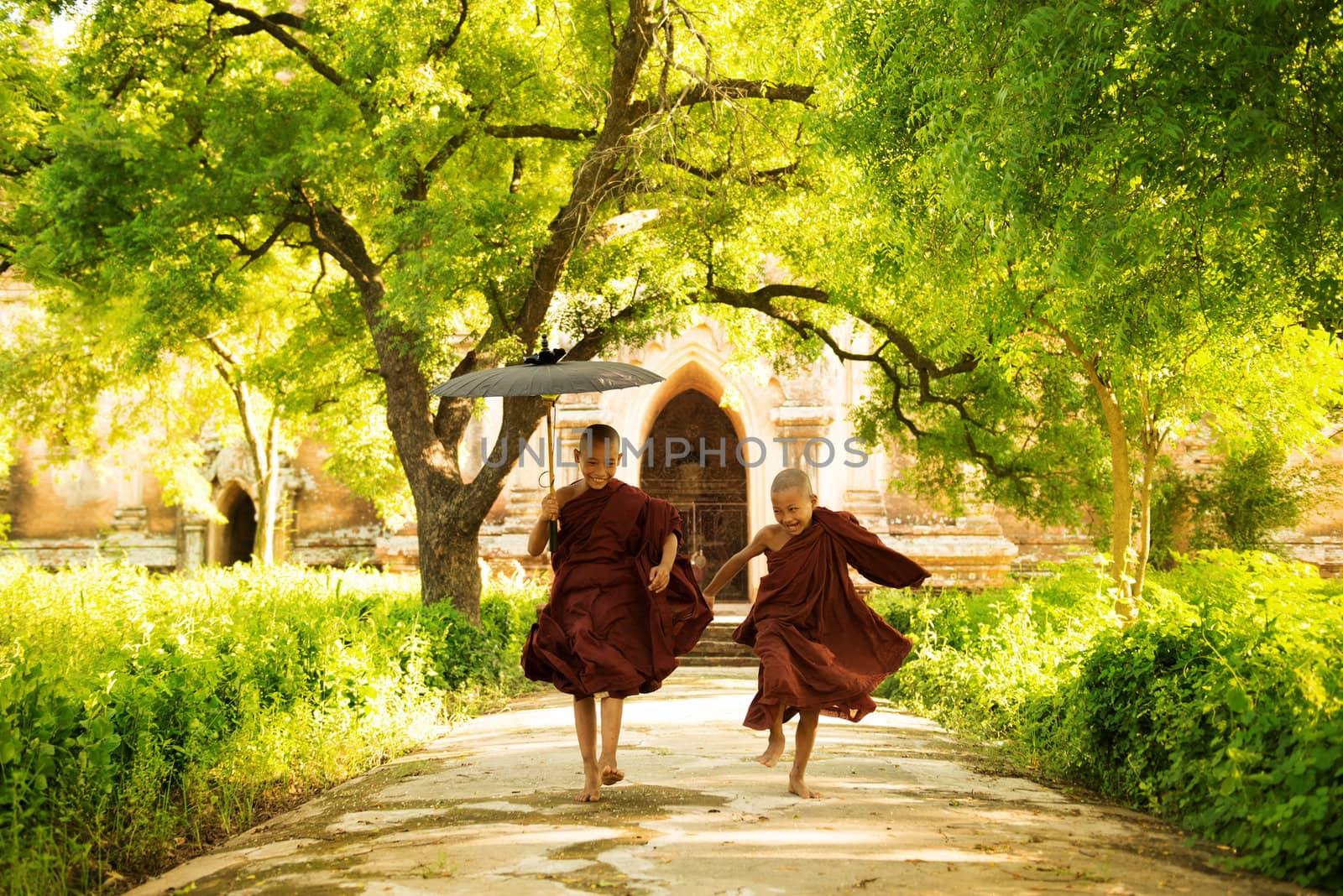 Two little monks running outdoors