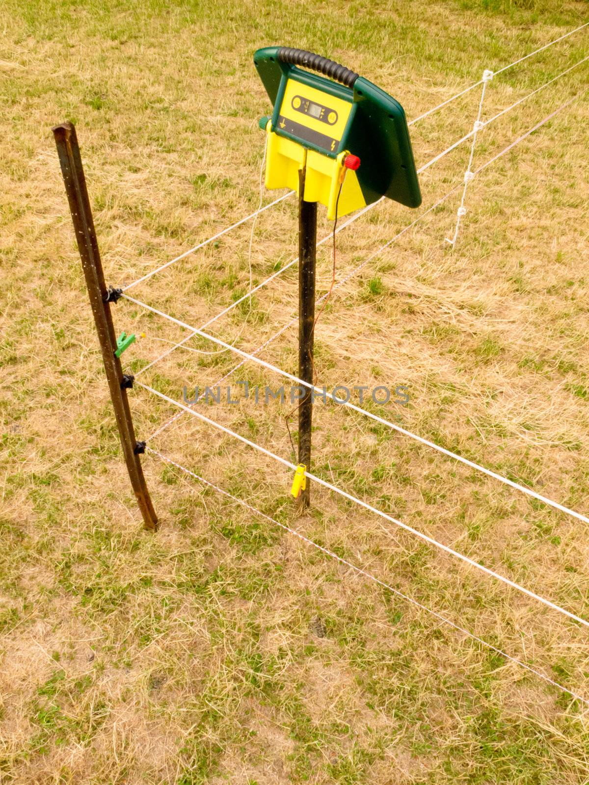 Electric fence charger mounted on a pole providing the energy for electrical livestock fencing out on rural farmland