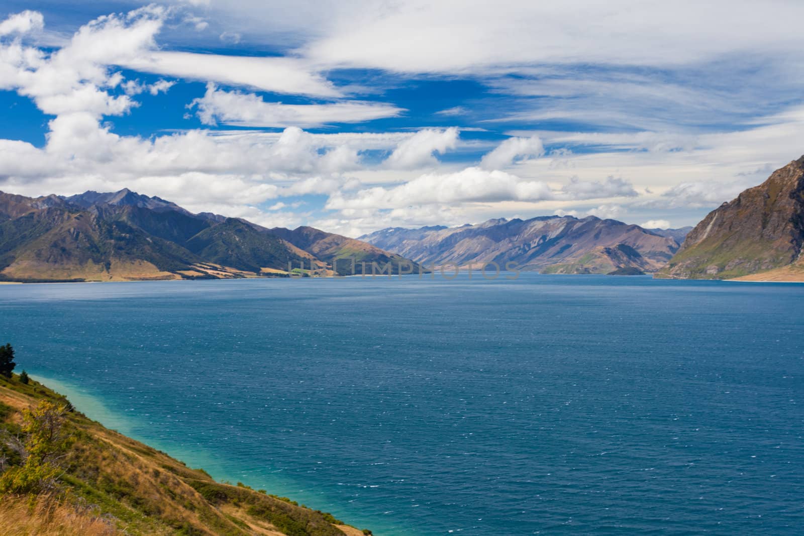 Vivid blue surface of big mountain Lake Hawea, Central Otago, New Zealand