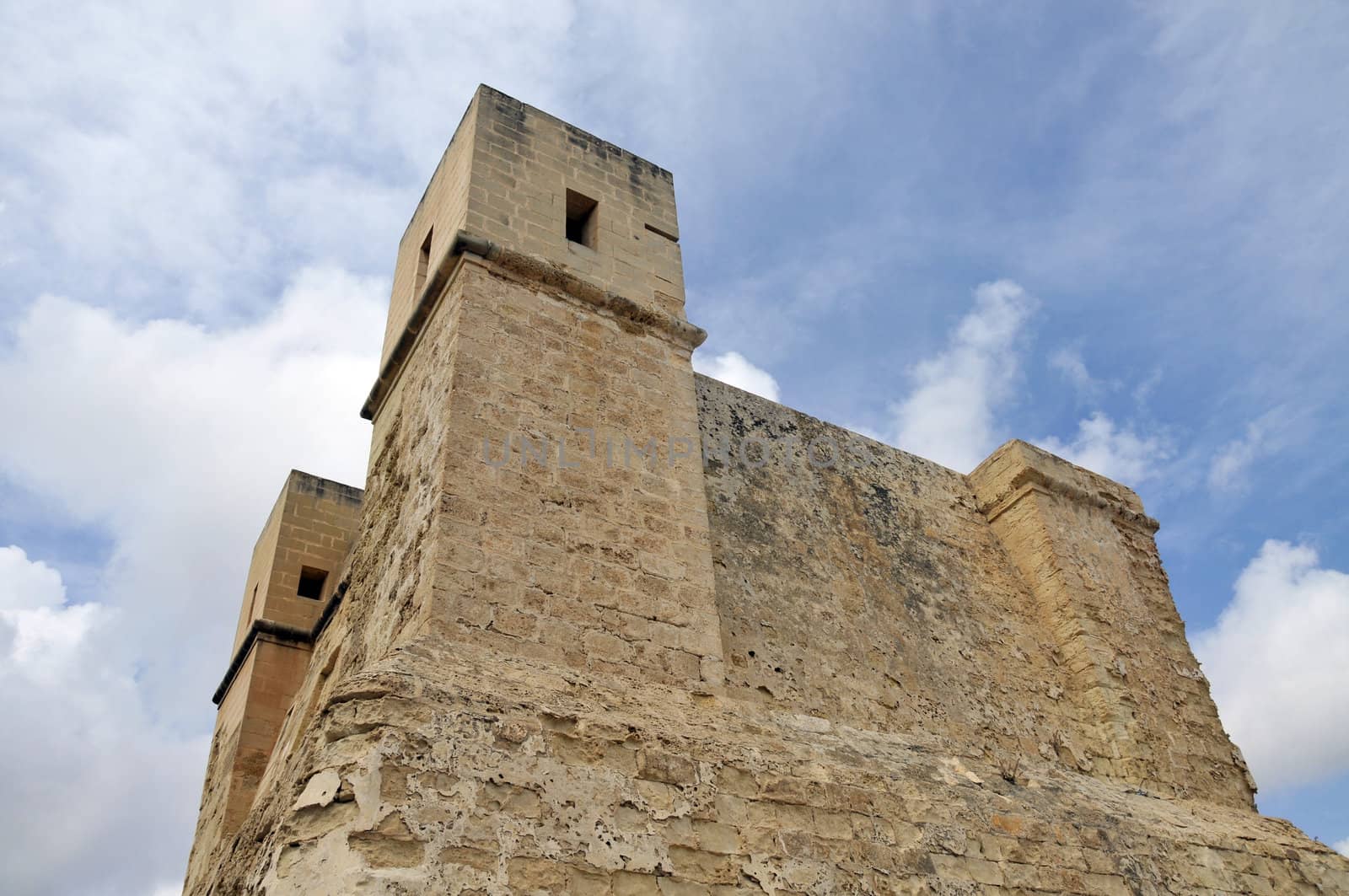 Very old tower on Malta with blue sky and clouds