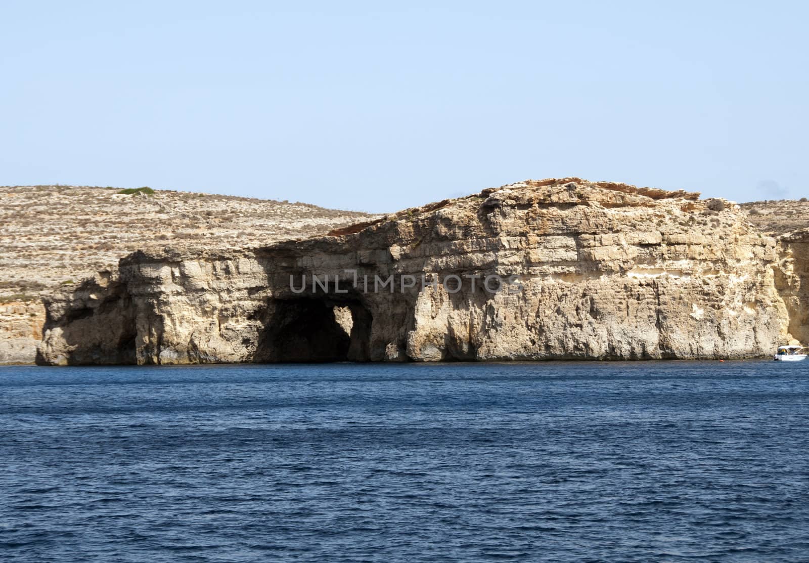 Blue sea and rocks on the malta beach with blue sky by compuinfoto