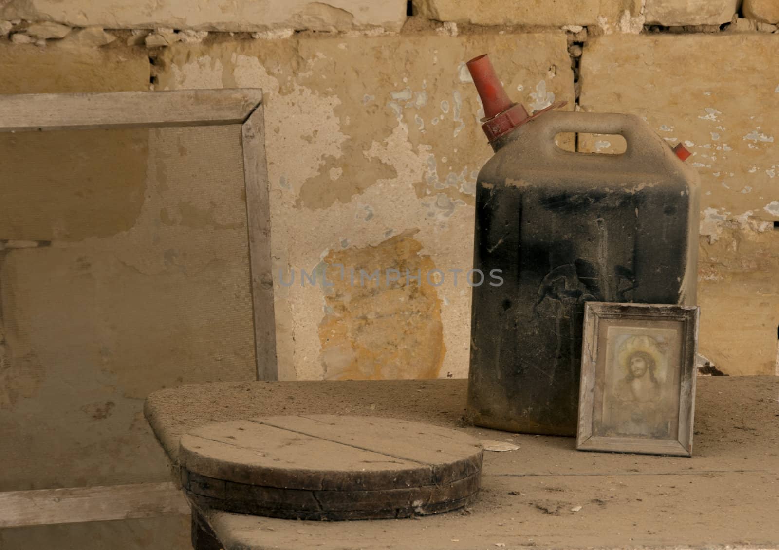 old jerrycan and painting on table full of brown dus