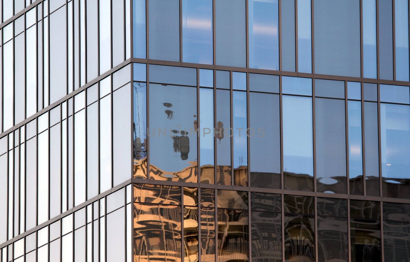 Large wall of glass windows at a tall building.