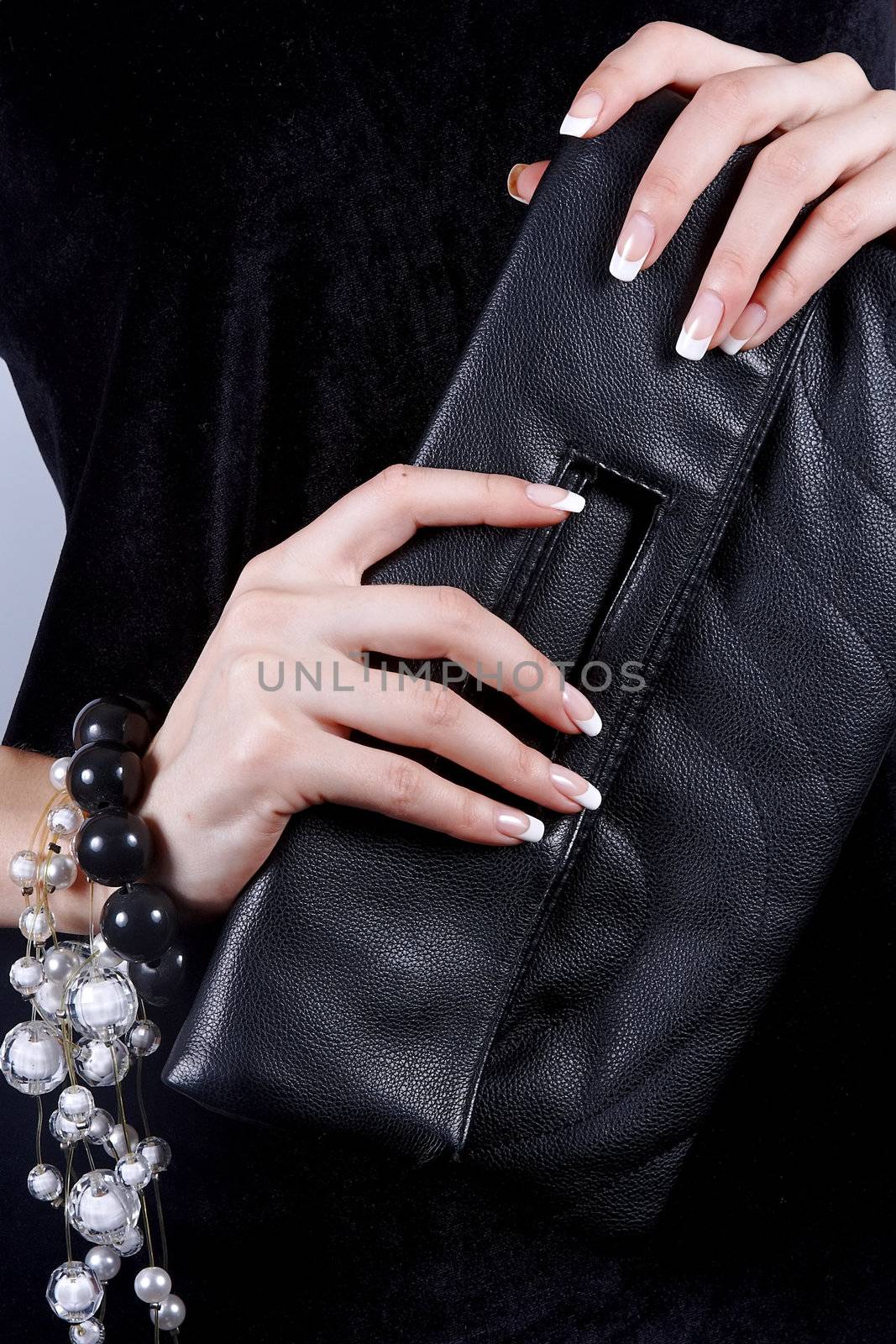 Beautiful female hands with manicure with a handbag by Azaliya