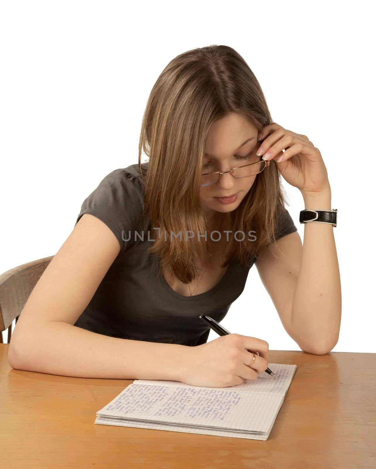 The girl in glasses writes to writing-books on a white background