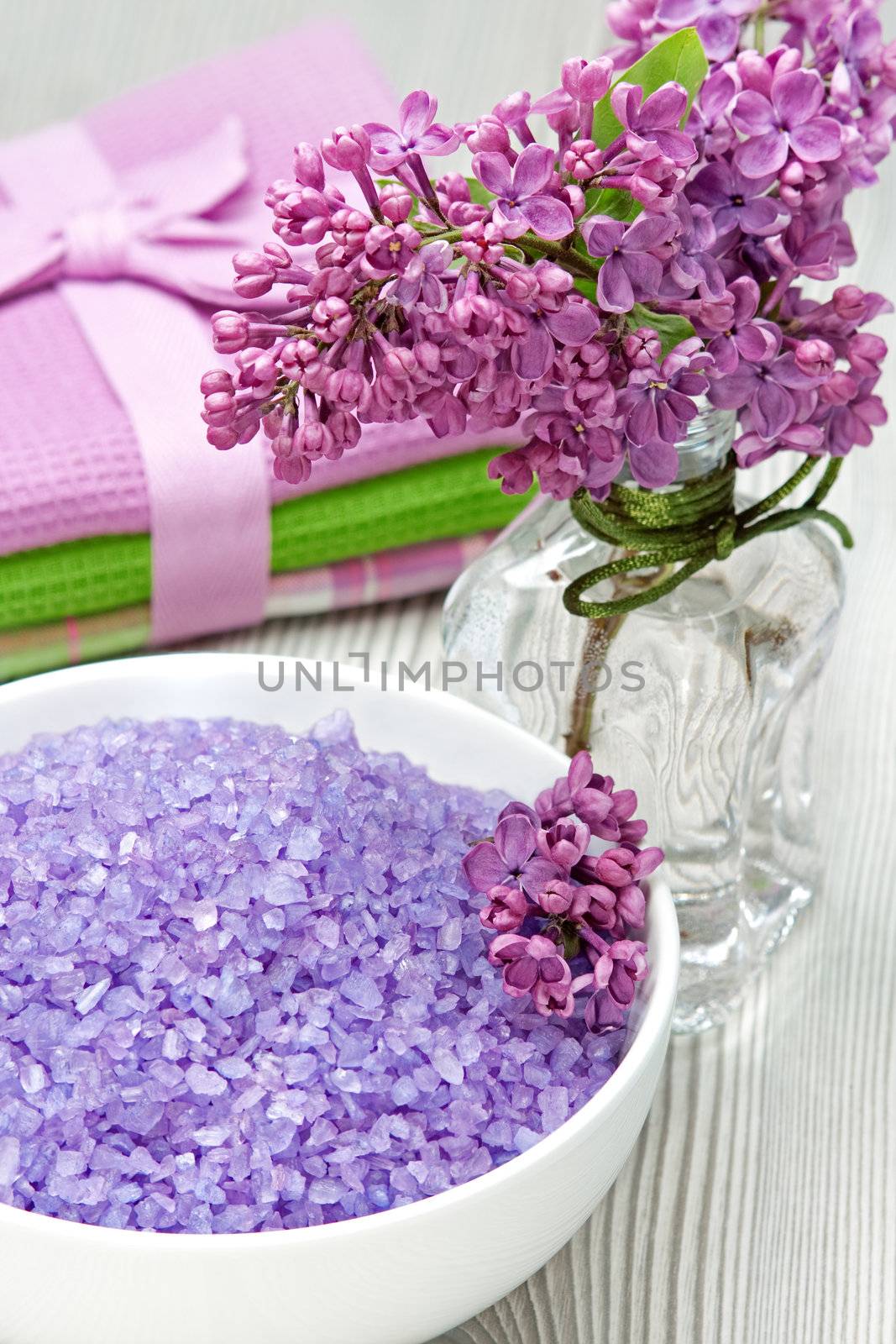 Sea-salt  and a bouquet of lilacs on a wooden background 