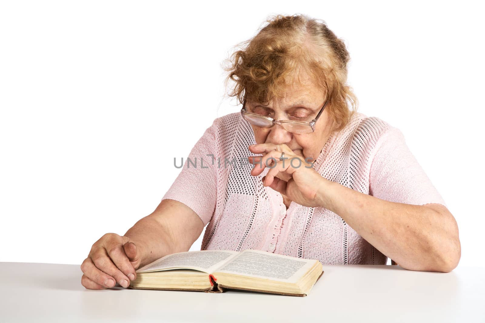 The old woman in points thoughtfully looks in the book on a white background