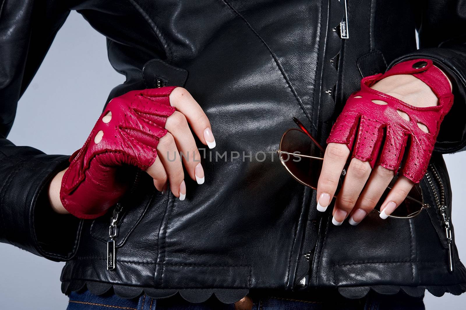 Women's hands with a manicure with sunglasses in stylish gloves 